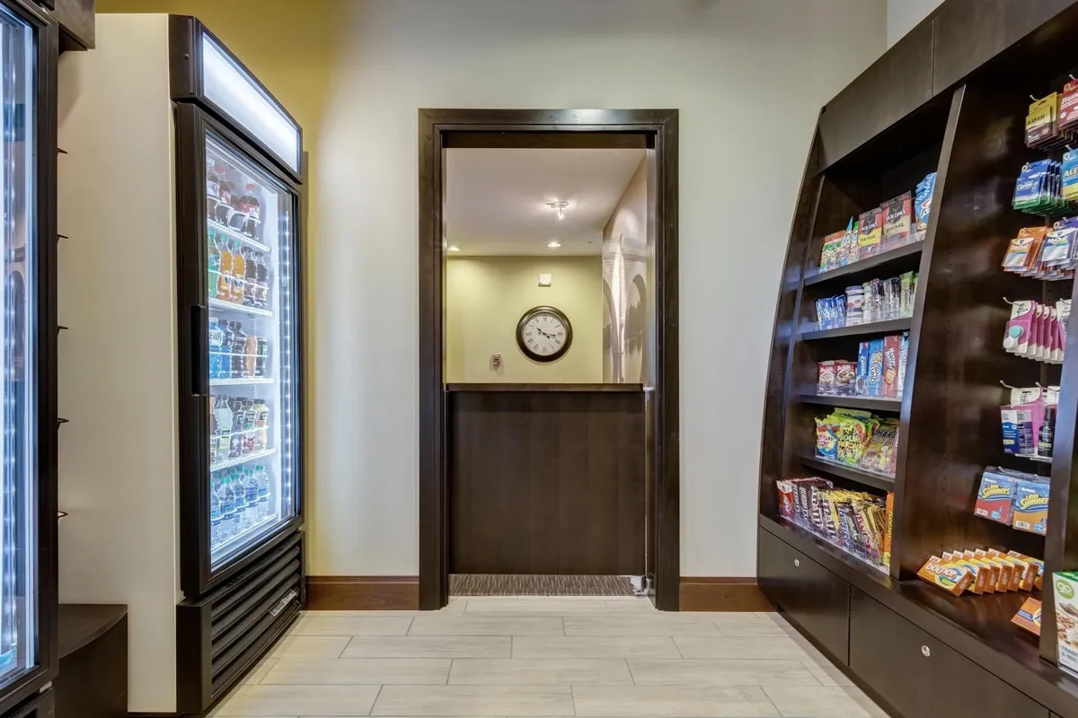 A convenient snack and vending area featuring a well-stocked machine, snack display, and a visible clock. The space offers quick food options for guests on-the-go or between meals.