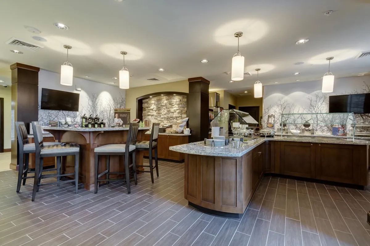 A cozy dining area with a wooden counter, stone wall accents, and comfortable seating. The space invites guests to enjoy meals, socialize, or relax, reinforcing the idea of the suite as a hub for nourishment and connection.