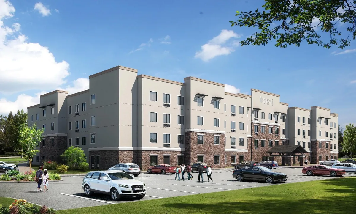 This exterior image features the hotel building's welcoming facade, entrance awning, surrounding landscaping, and guests walking outside. The bright, inviting atmosphere sets the stage for family arrivals and departures, presenting the hotel as the perfect base for exploring nearby attractions.
